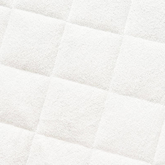 Close-up of quilted bamboo mattress protector showing white padded fabric with diagonal quilting pattern