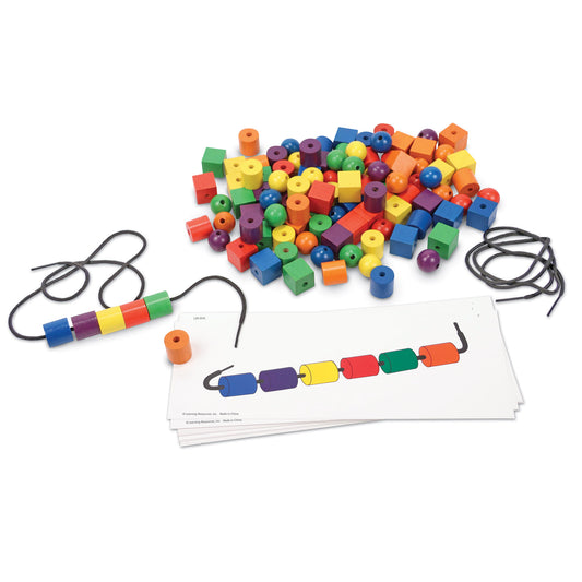Colorful beads in various shapes and colors with two black strings threaded with patterned beads, and pattern instruction cards below