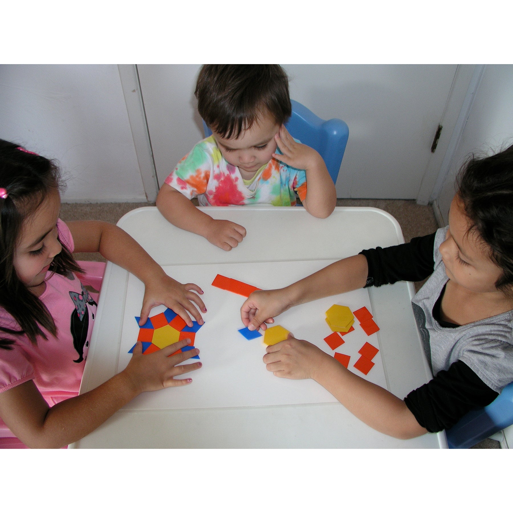 EduStic Pattern Smart Game with colorful geometric shapes in red, blue, and yellow being arranged by children