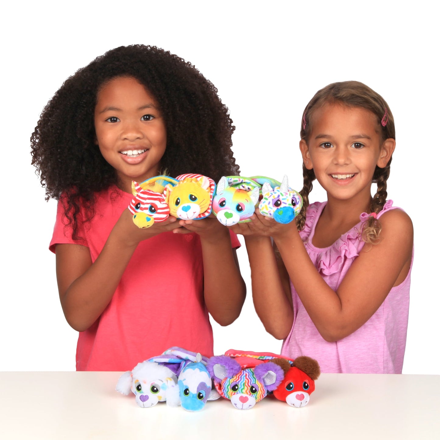 Two children holding colorful plush Cutetitos Budditos characters with different patterns and expressions