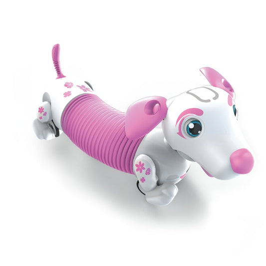 White and pink interactive robotic puppy with ribbed magenta midsection, large blue eyes, flower details, and articulated limbs on plain background