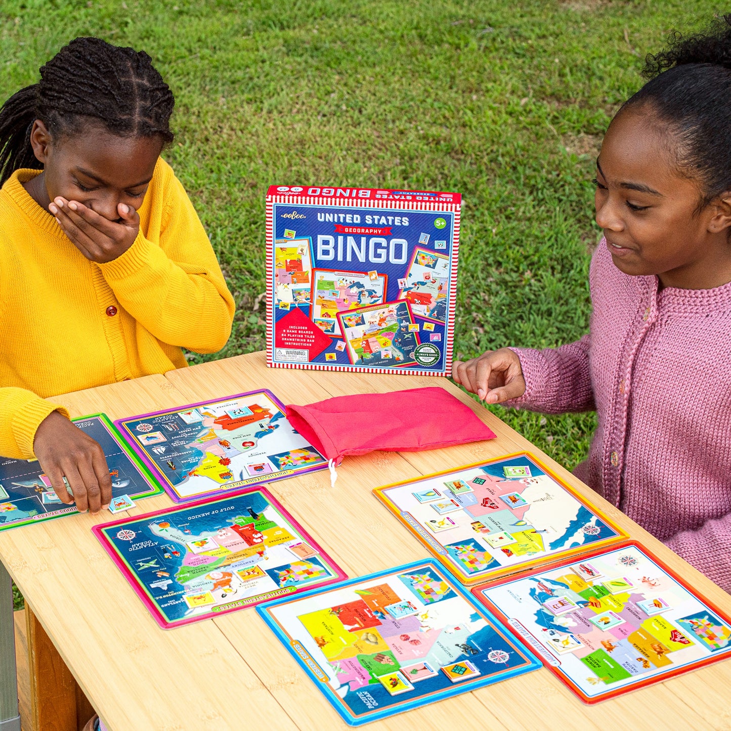 United States Geography Bingo game with colorful game boards and cards on wooden table