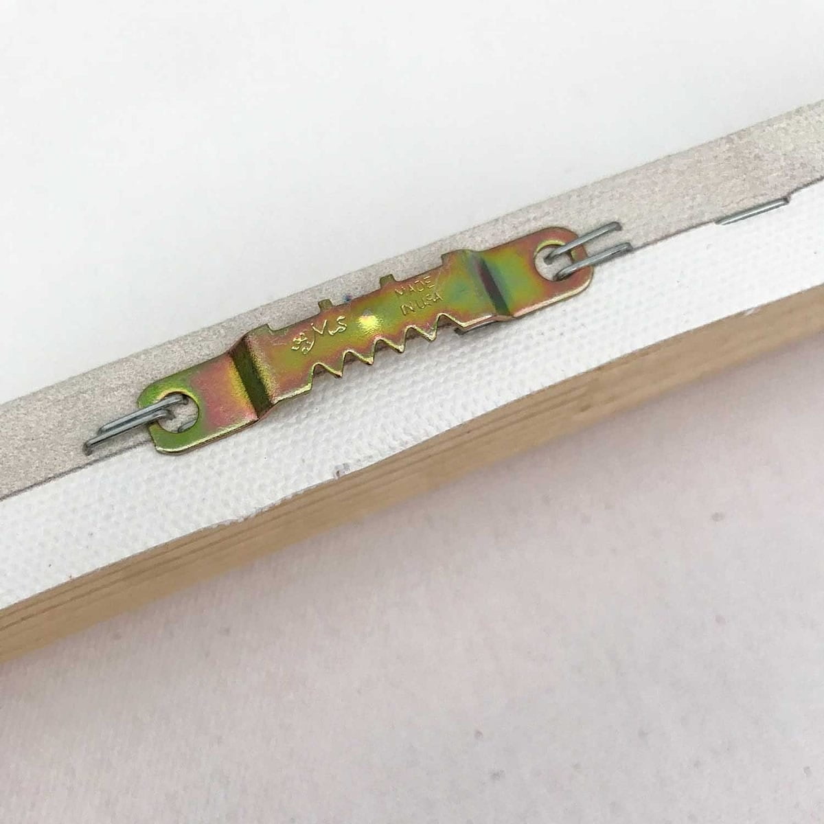 Close-up of a white zipper with iridescent metal slider on canvas art