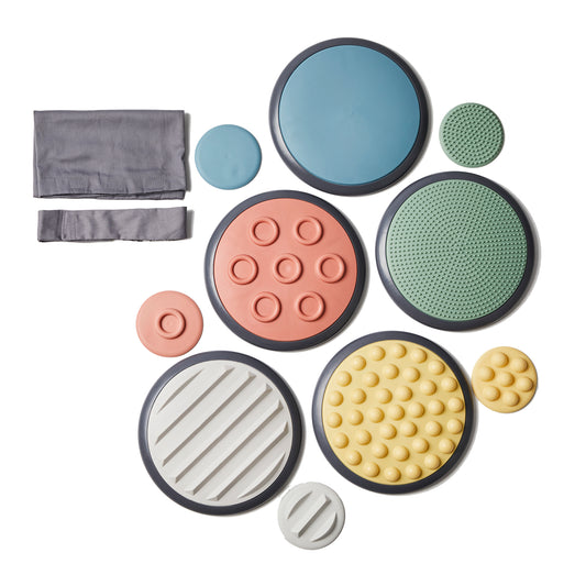 GONGE Tactile Discs Nordic set with gray storage pouches, featuring seven circular discs in blue, coral, green, and cream with varied textures including smooth,
