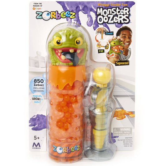 Orbeez Monster Oozer Shaggy Shedder Sam toy on package, featuring lime-green monster head with orange container of water beads and yellow Orbeez accessory