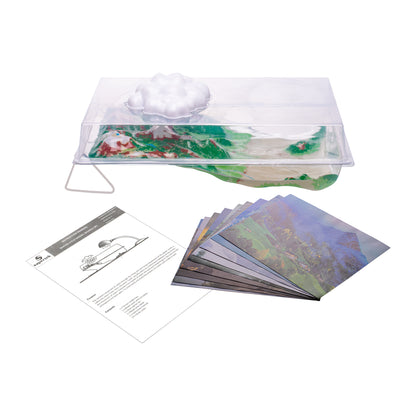 Water cycle demonstration kit contents including clear plastic chamber with cloud feature, landscape scene cards, and instruction manual