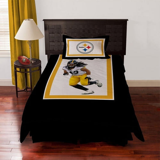 Pittsburgh Steelers bedding set on bed, featuring player in yellow and black uniform with Steelers logo pillow and black comforter