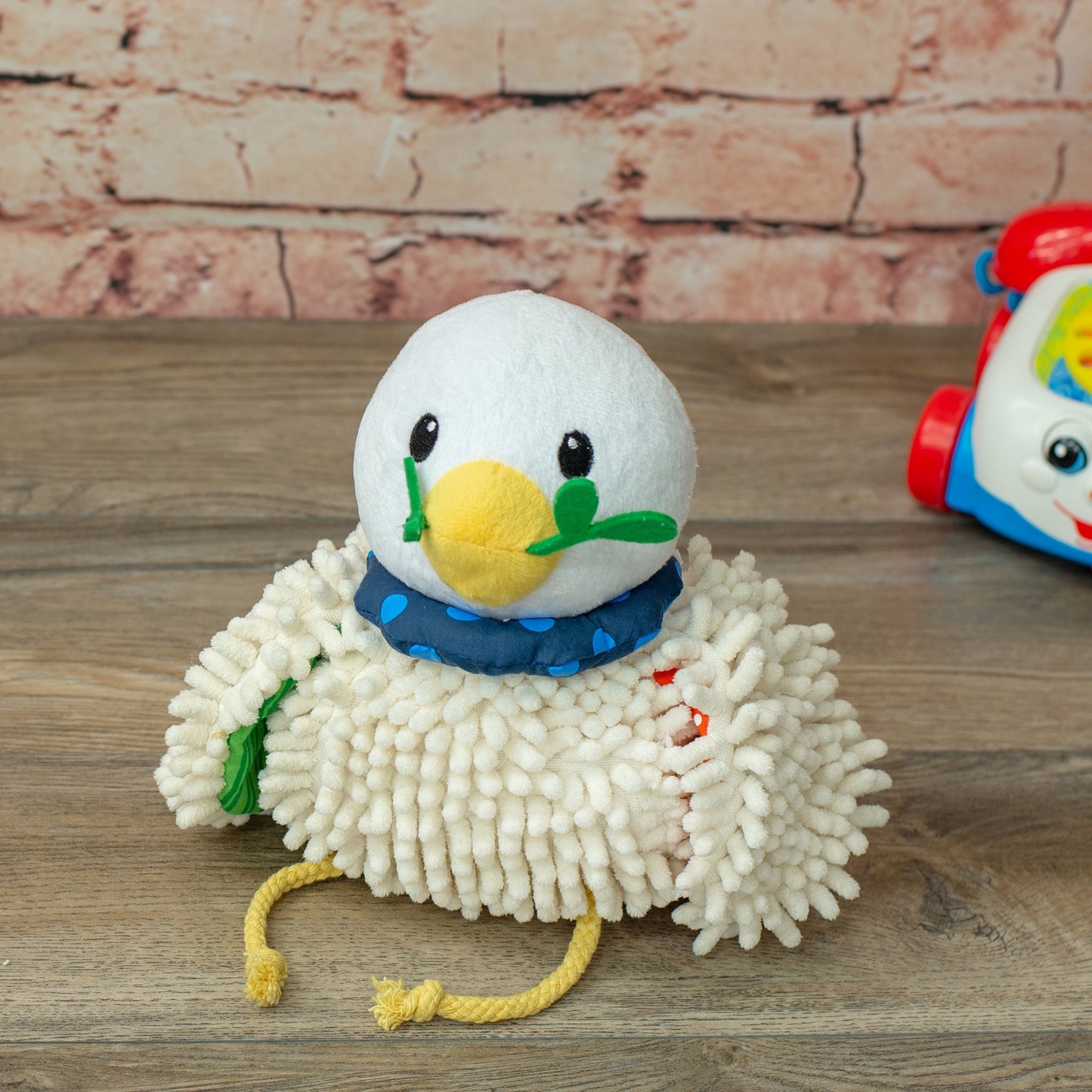 Wee Believers Lil Prayer Buddy Dottie plush toy with white fuzzy body, yellow beak, black eyes, blue polka-dot bandana, and green wings