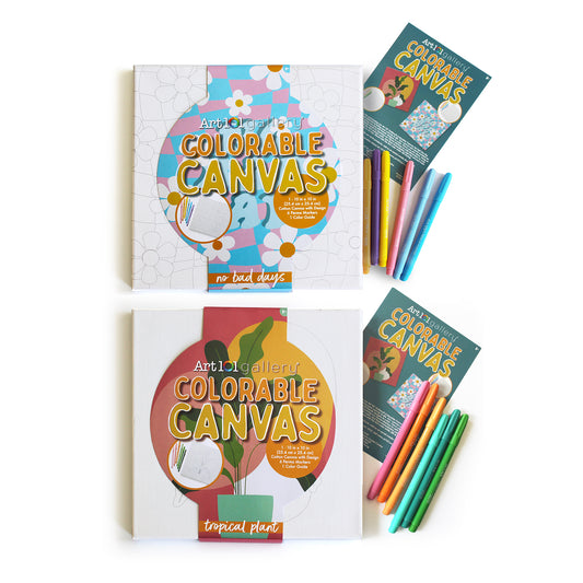 Two colorable canvas art kits displayed with markers. Top: floral design canvas with "no bad days" text and assorted markers. Bottom: tropical plant design canv
