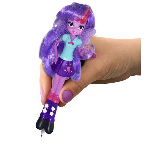 Small purple-haired doll with wings held in hand, wearing turquoise top and purple skirt with star design, modeled by a child