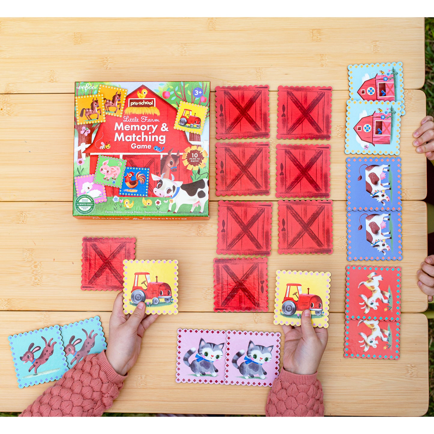 Memory & Matching Game: Little Farm - Red barn tiles with farm animals and tractors on wooden surface