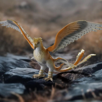 Wizarding World Thunderbird toy with orange wings and white body on dark rocks