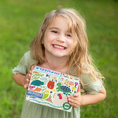 Young girl holding 20 Piece Petite Pets Puzzle with colorful animals and nature designs