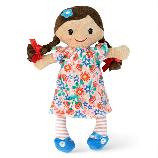 Soft rag doll with brown braided hair, blue flower clip, smiling face, wearing colorful floral dress with red ribbon bows on pigtails and blue feet