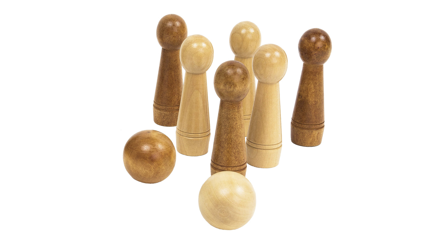 Wooden tabletop bowling game with five natural wood pins in two tones and two wooden balls on plain background