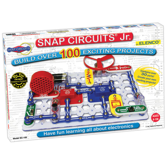 Snap Circuits Jr. electronic building set with red and blue snap-together components, battery pack, motor, and red propeller on white base grid
