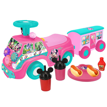 Disney Minnie Mouse pink and turquoise foot-to-floor ride-on camper set with attached trailer, steering wheel, cup holders, pretend food items, and character gr