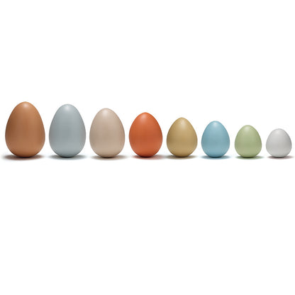Eight smooth plastic eggs in brown, gray, beige, orange, gold, blue, green, and white, arranged in a row on white background