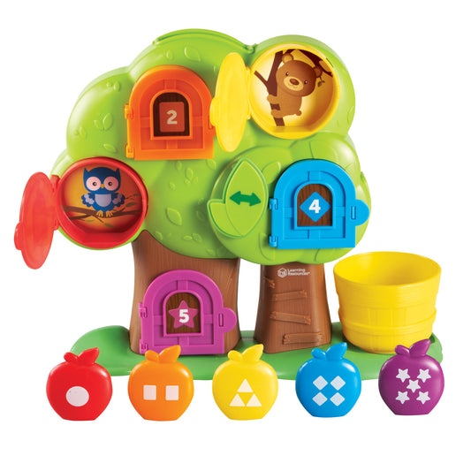 Interactive green tree toy with colorful numbered doors, animal characters inside, and five shape-patterned balls below for color and number recognition play