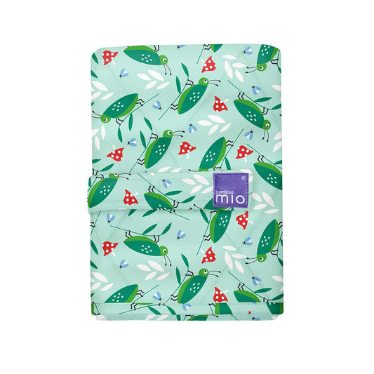 Bambino Mio portable changing mat with mint green background printed with green grasshoppers, red mushrooms, white leaves, and blue flowers