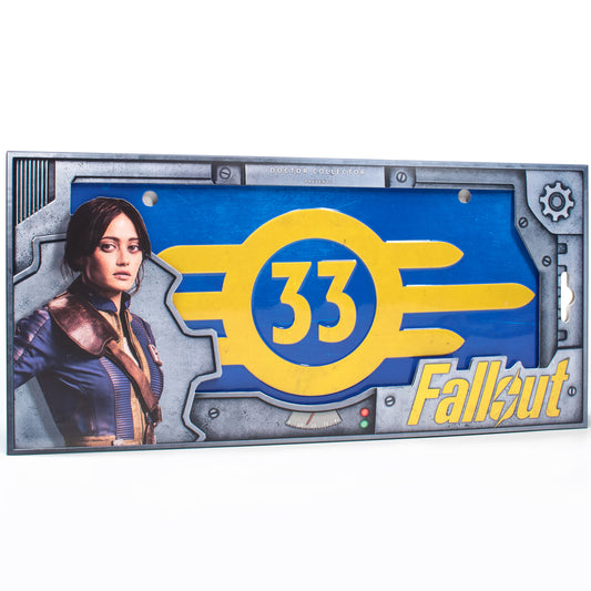 Fallout Vault 33 collectible license plate with yellow Vault-Tec logo on blue background and character portrait on left side