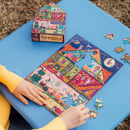 eeBoo Haunted House 100 Piece Puzzle being assembled by child's hands on blue surface