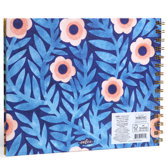 Spiral-bound artist sketchbook with blue foliage and coral flower pattern cover, gold binding visible on spine