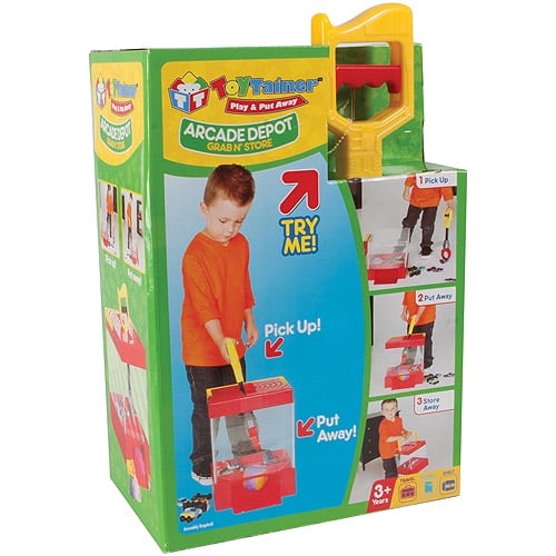 Toytainer Arcade Depot Interactive Toy Storage, green and red arcade-style cabinet with yellow claw crane mechanism, modeled by a child in orange shirt picking