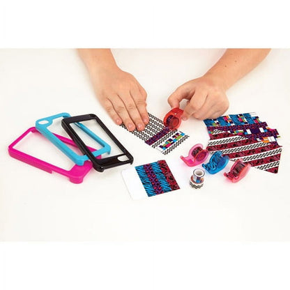 Modeled by a child's hands decorating a phone case with colorful patterned tape strips, plastic frames in pink and blue, and dispenser tools