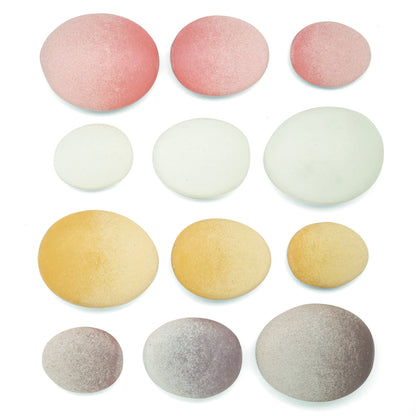 Twelve smooth, polished stones in pink, white, yellow, and gray arranged in four rows, decreasing in size from left to right