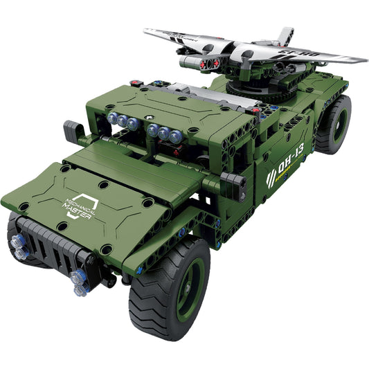 Green military-style R/C carrier vehicle with mounted aircraft launcher and white fighter jet on top, displayed against plain background