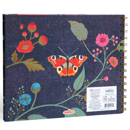 Victoria's Artist Sketchbook with spiral binding, navy cover featuring illustrated red and pink flowers, blue blooms, green leaves, and a red butterfly with eye