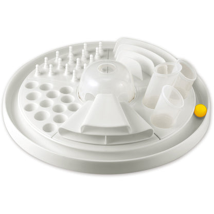White circular cat activity toy with multiple play stations including holes, pegs, tunnels, and compartments; yellow ball visible on side