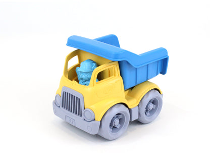Yellow and blue dump truck toy with gray wheels and blue driver figure inside cab on plain white background