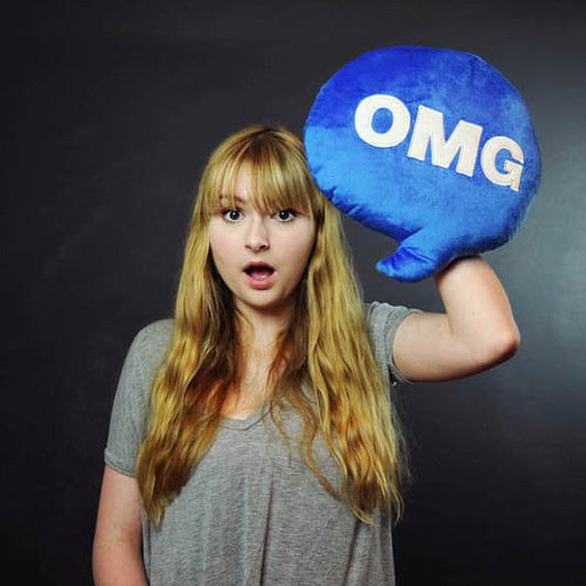 Child modeled by a girl holding blue plush OMG chat pillow, expressing surprised reaction