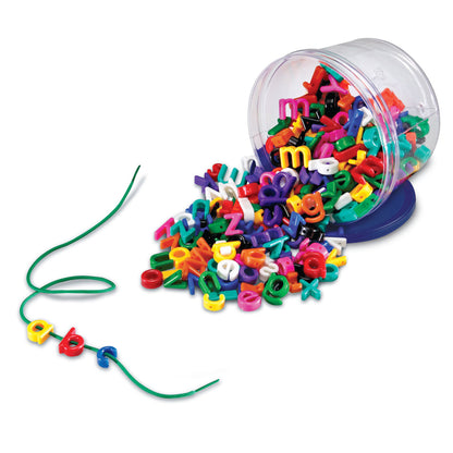 Colorful alphabet letters spilling from clear tipped bucket with green lacing string and threaded letter beads