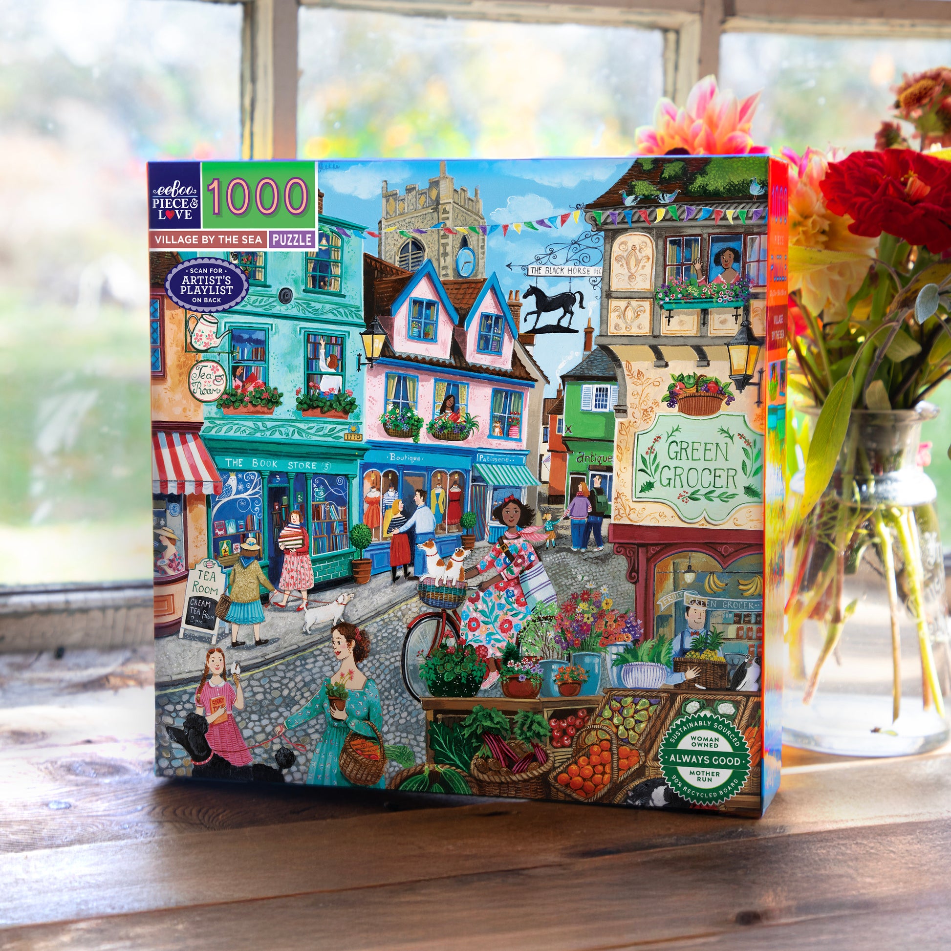 eeBoo Village By The Sea 1000-Piece Puzzle featuring colorful seaside village shops and characters
