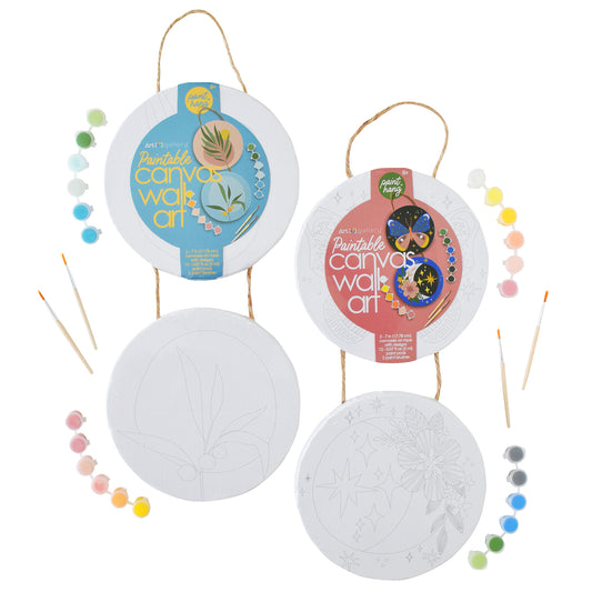 Art 101 Paintable Canvas Wall Art Kit with two circular canvases featuring botanical and celestial designs, rope hangers, paintbrushes, and paint palette beads