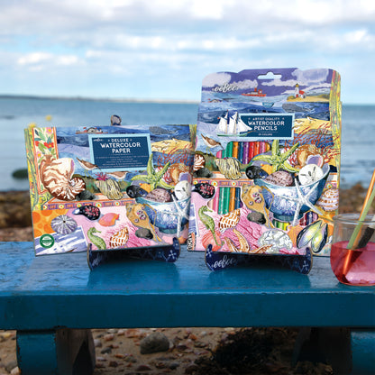 eeBoo Seashells Watercolor Pad with colorful pencils displayed on beach table