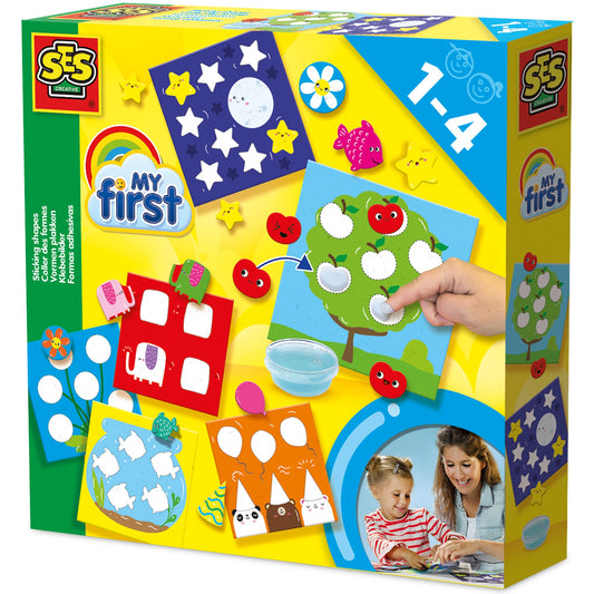 SES Creative My First Sticking Shapes Mosaic Art Activity Kit box showing colorful sticker scenes including a house, tree with apples, night sky, and flowers, m