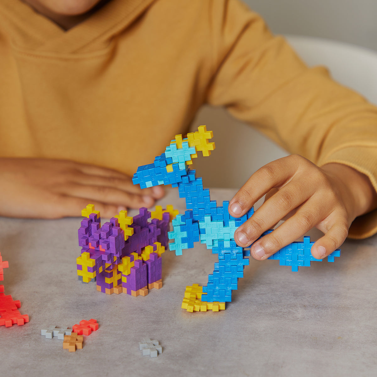 Plus-Plus Learn to Build Dinosaurs 400-piece set with blue dinosaur, purple castle, and colorful interlocking blocks