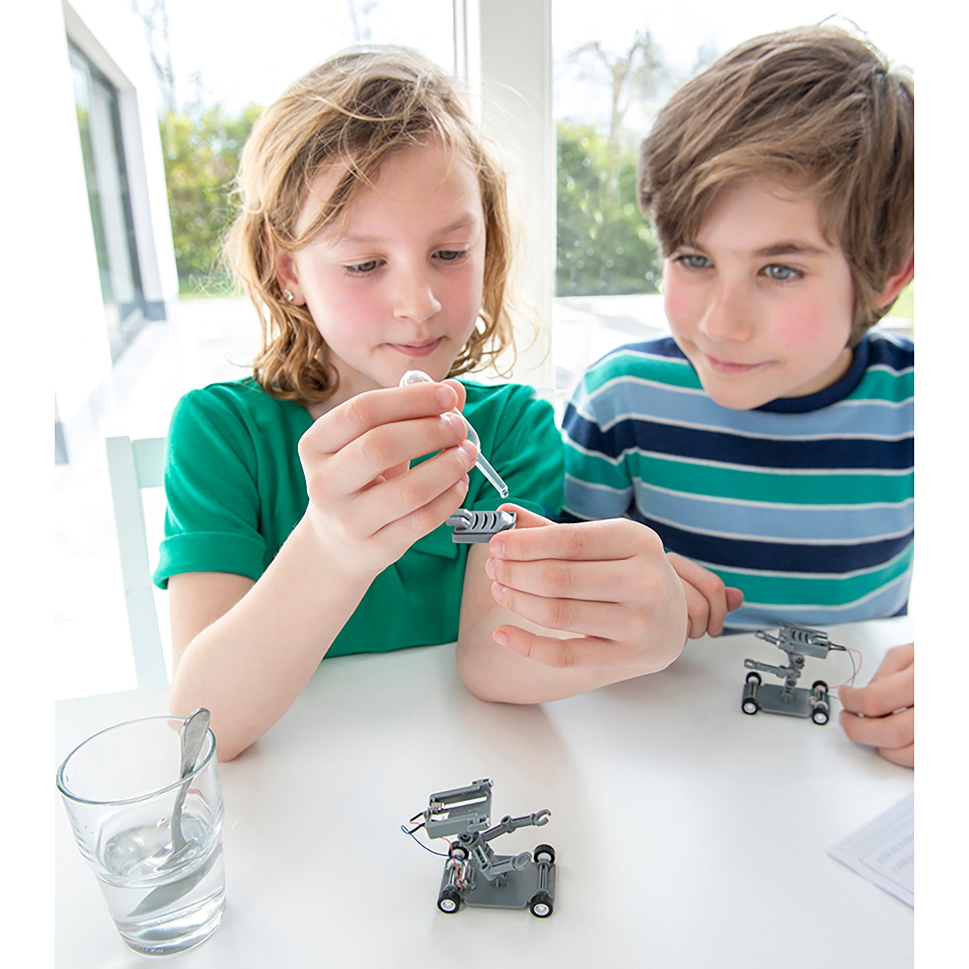 Green Science Salt-Powered Robot toy with kids assembling metal robot components