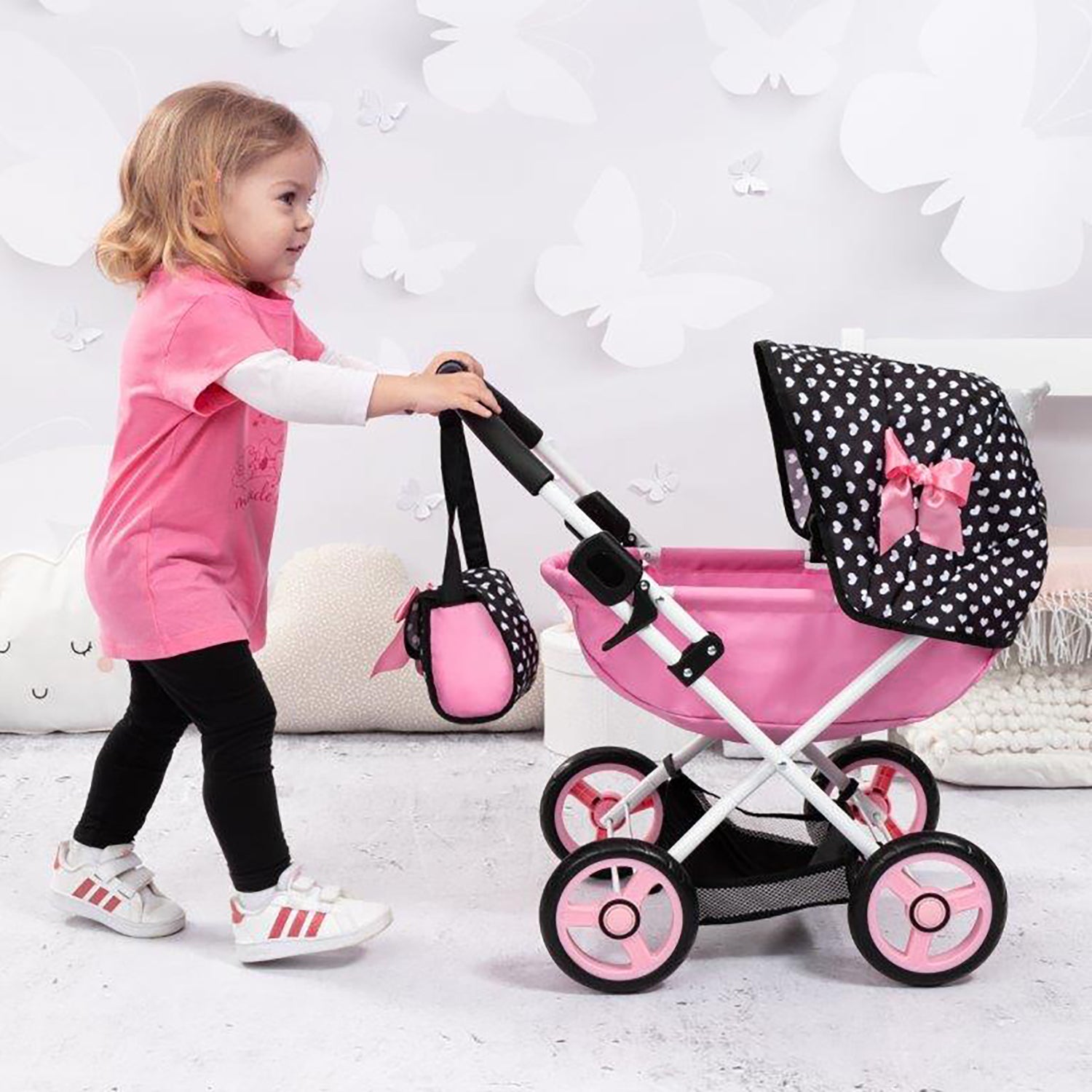 Bayer Design Dolls Pram Cosy with black polka dot canopy and pink fabric, child playing