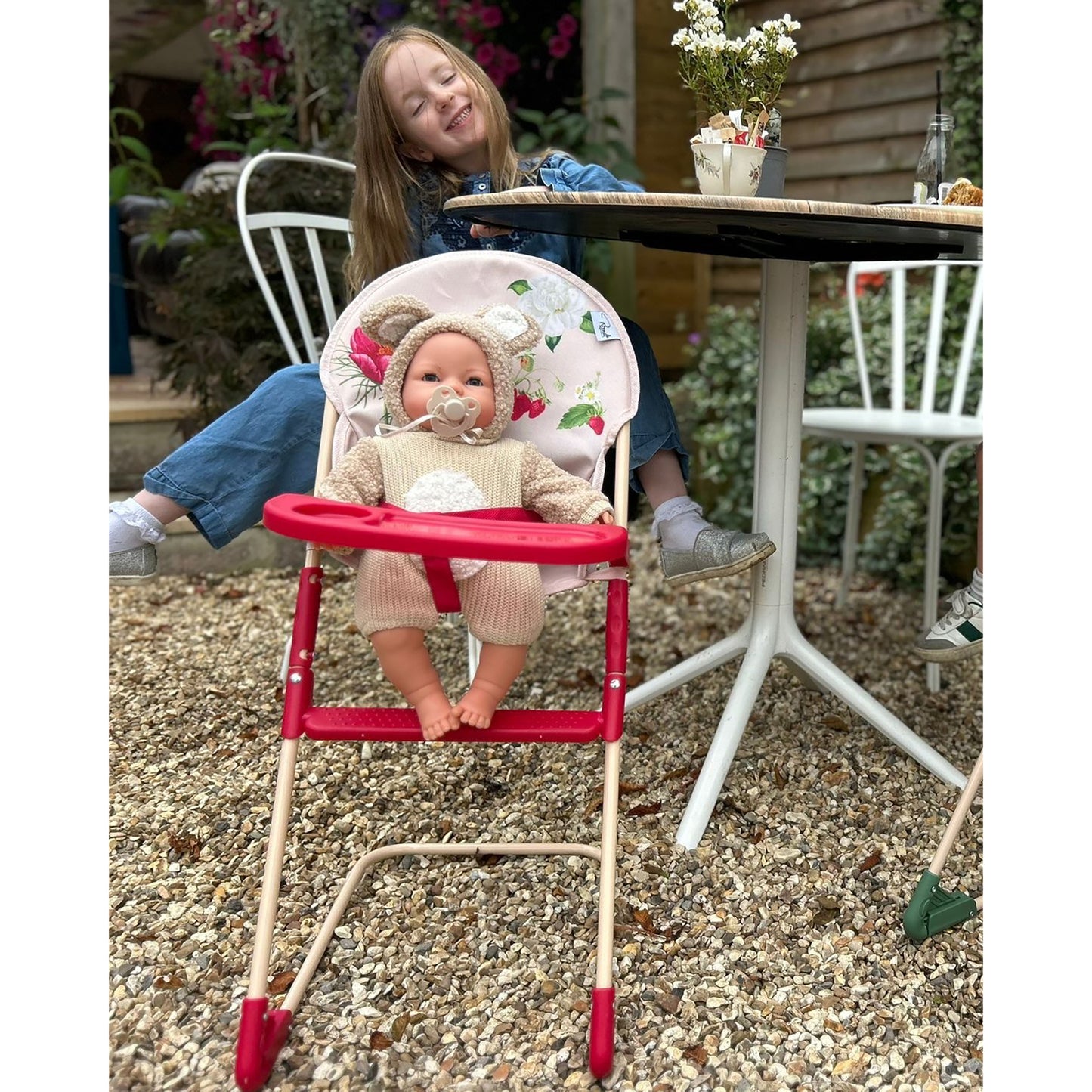 Roma RHS High Chair - Flora in red with doll seated, garden setting
