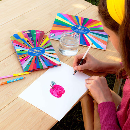Deluxe Watercolor Paper Pad Rainbow with colorful pencils and brush painting pink apple