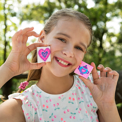 Girl holding Magnetic Mini Tile Art with pink heart design and colorful patterns