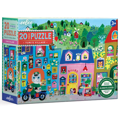 eeBoo Yumi's Village 20 piece jigsaw puzzle box featuring colorful illustrated village scene with houses, trees, animals, and a cat on a blue scooter