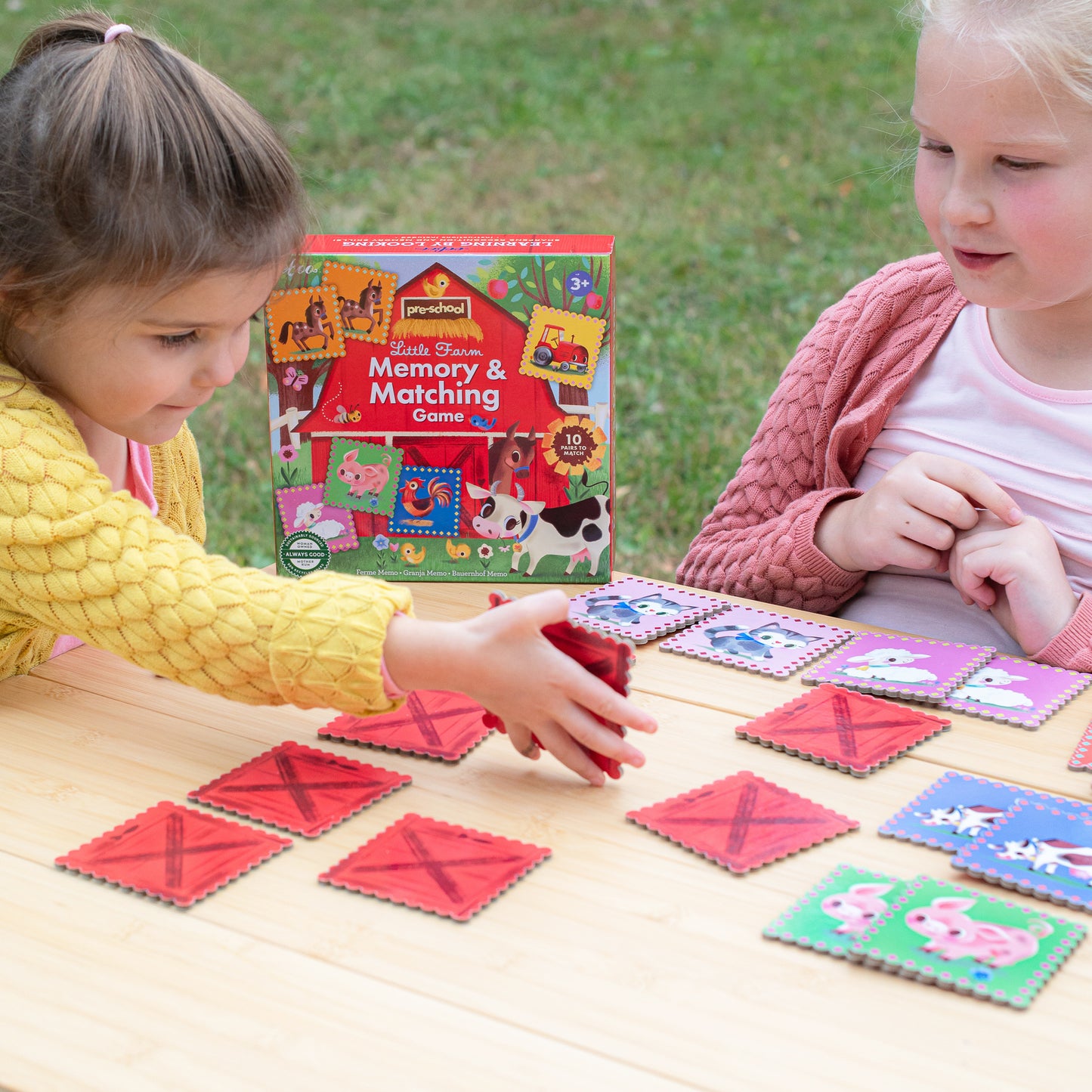 Little Farm Memory & Matching Game with colorful farm animal cards being played by two young children outdoors