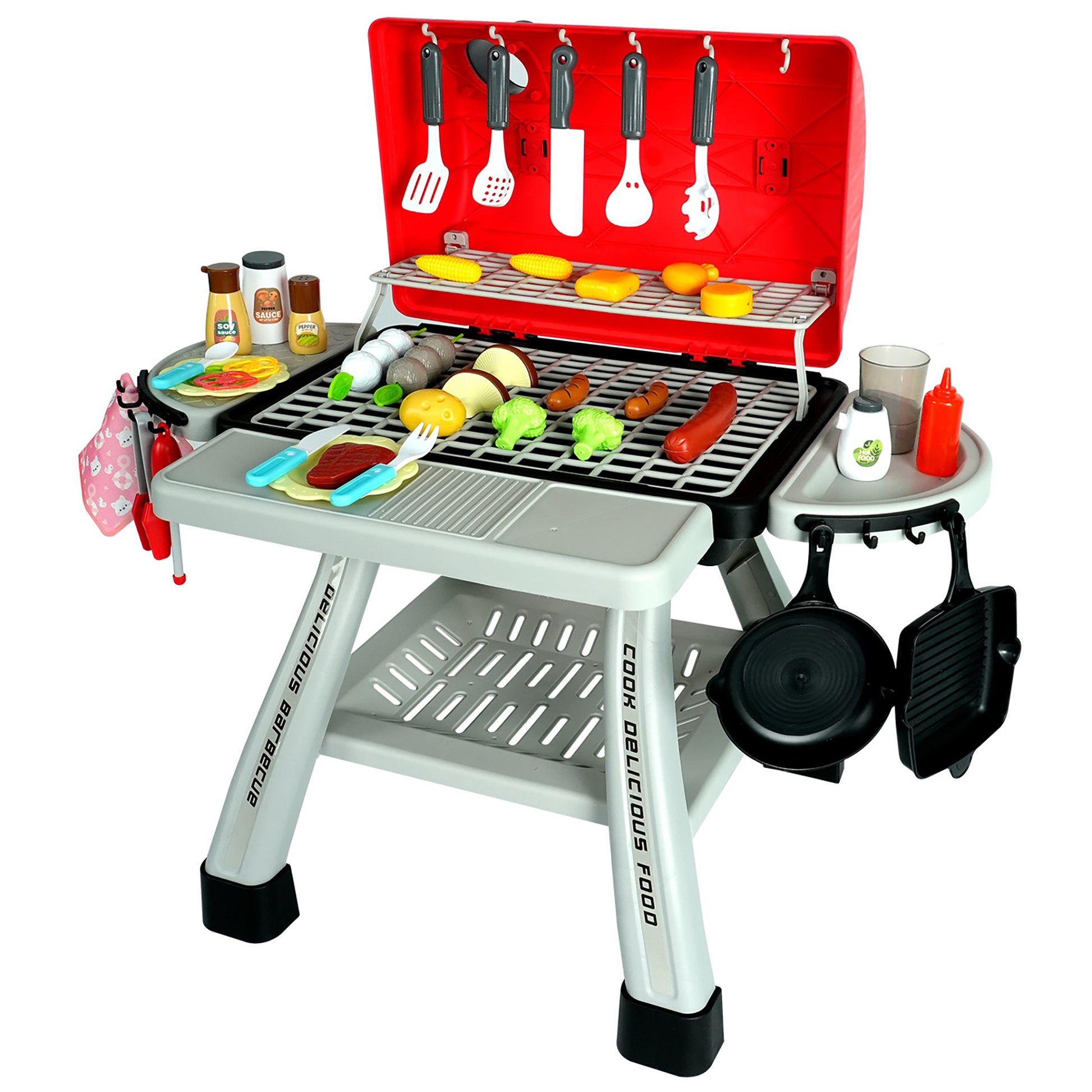 Toy BBQ grill playset with red hood, black grill grates, pretend food items including corn and vegetables, cooking utensils hanging from red backboard, side tab