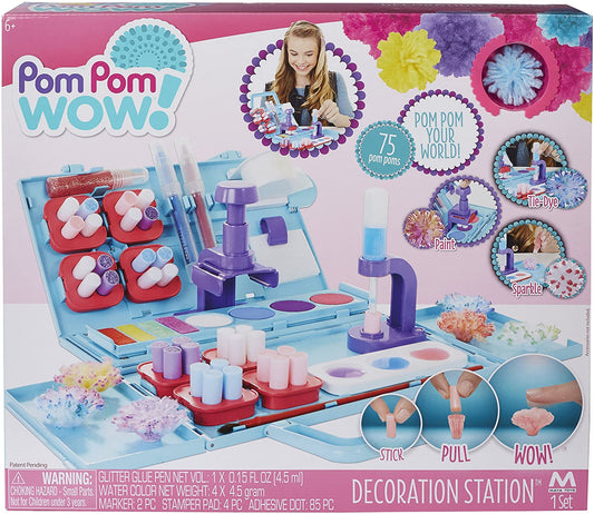 Pom Pom Wow Decoration Station craft kit with blue and purple machine, red pom pom holders, colorful markers, paint, glitter pens, and 75 pom poms; modeled by a